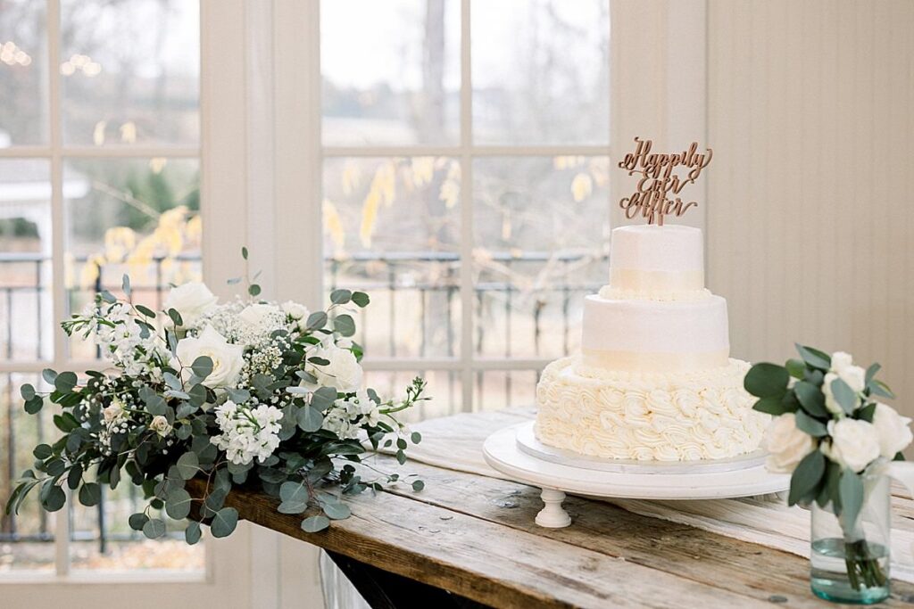 Details of a three tier wedding cake with white flowers around it 