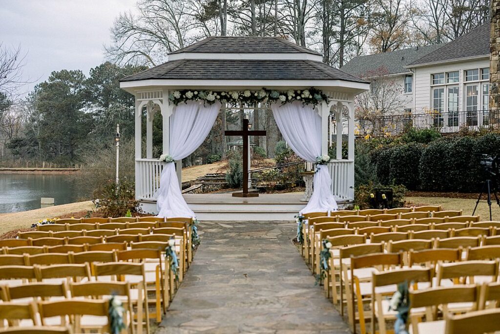 A wedding ceremony setup at a gazebo with a wooden cross and white drapes Little River Farms, wedding venue in Milton Georgia 