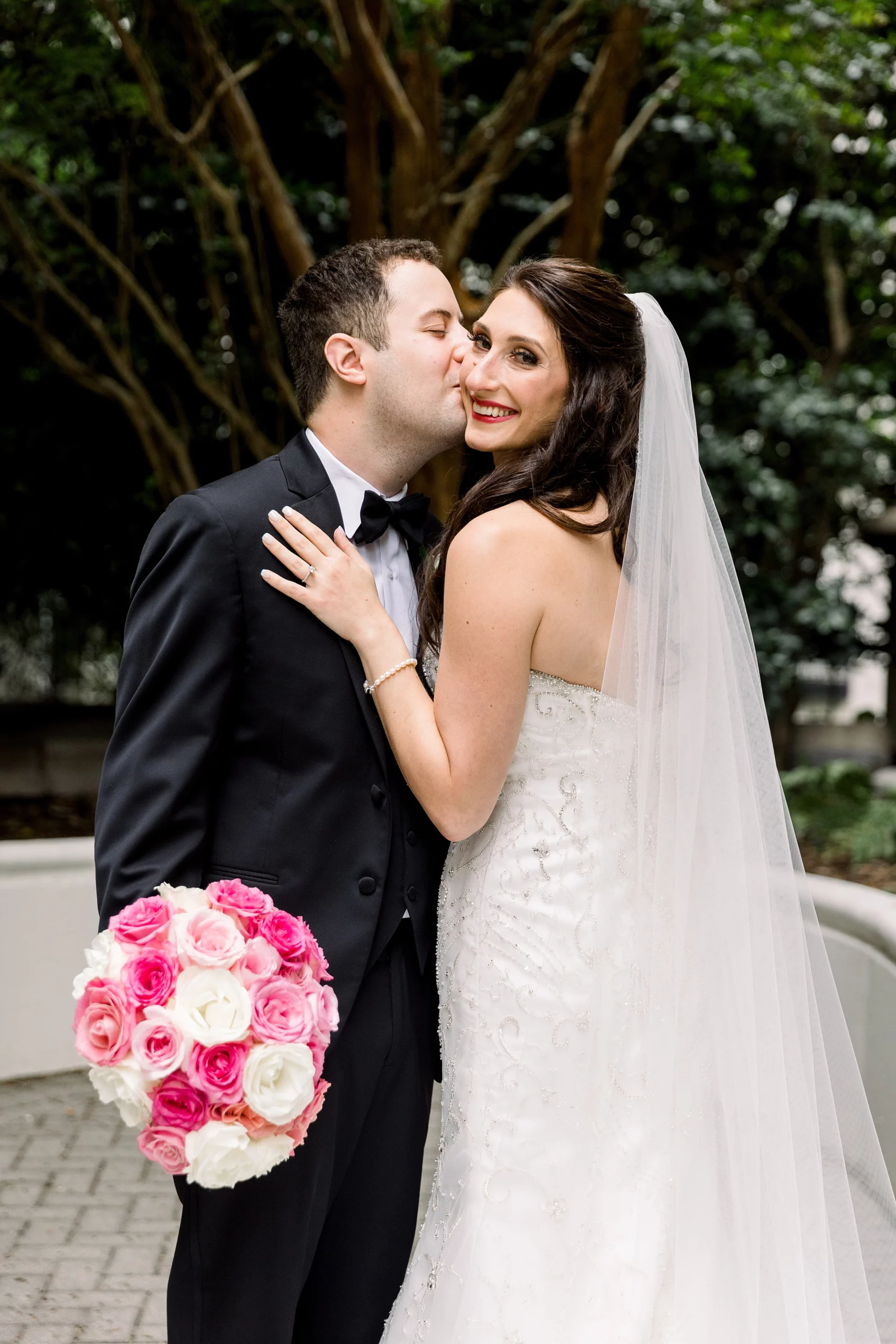 groom kissing his bride on the cheek at their Georgian Terrace wedding
