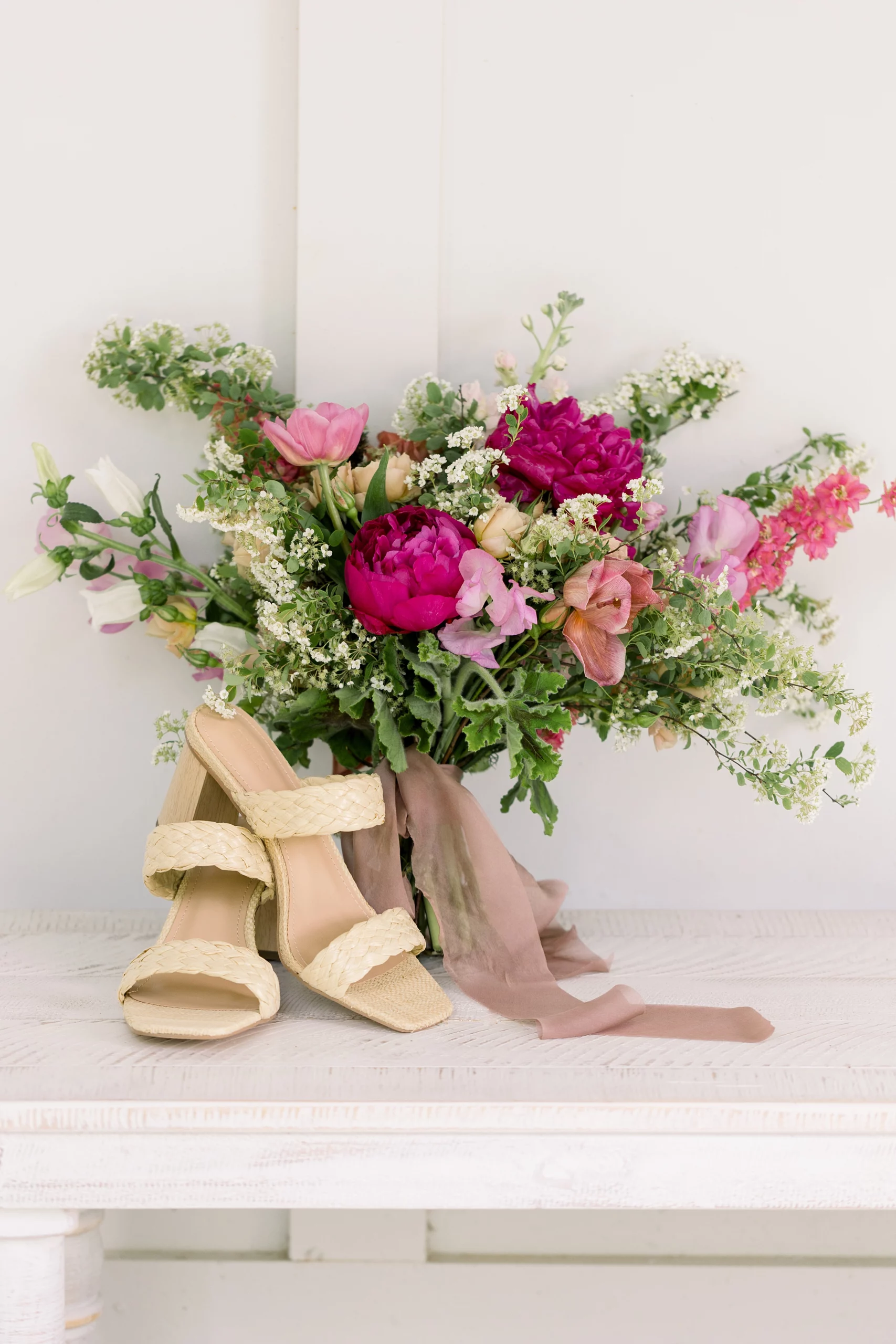 details of pink bridal bouquet and heels