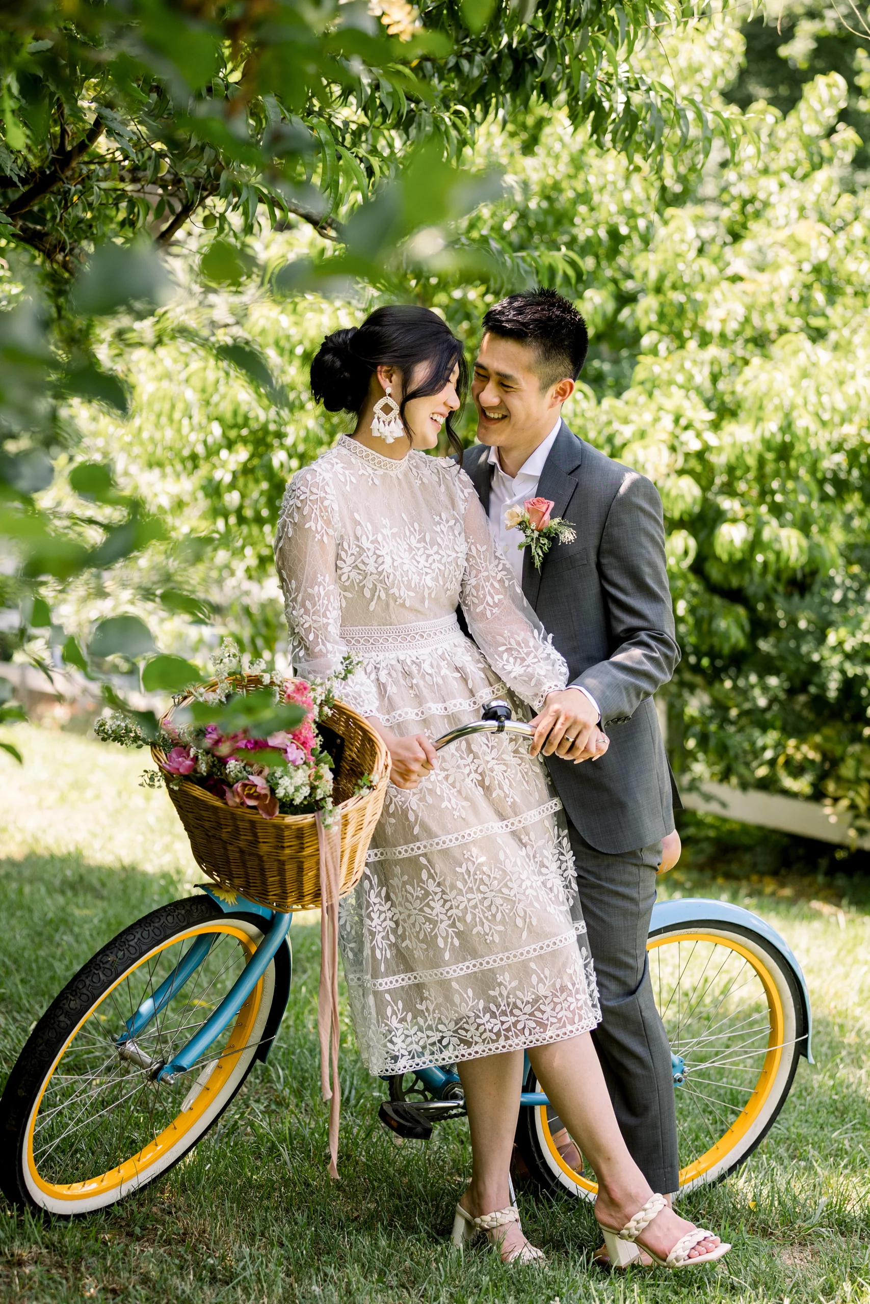 bride and groom on a bike in a garden