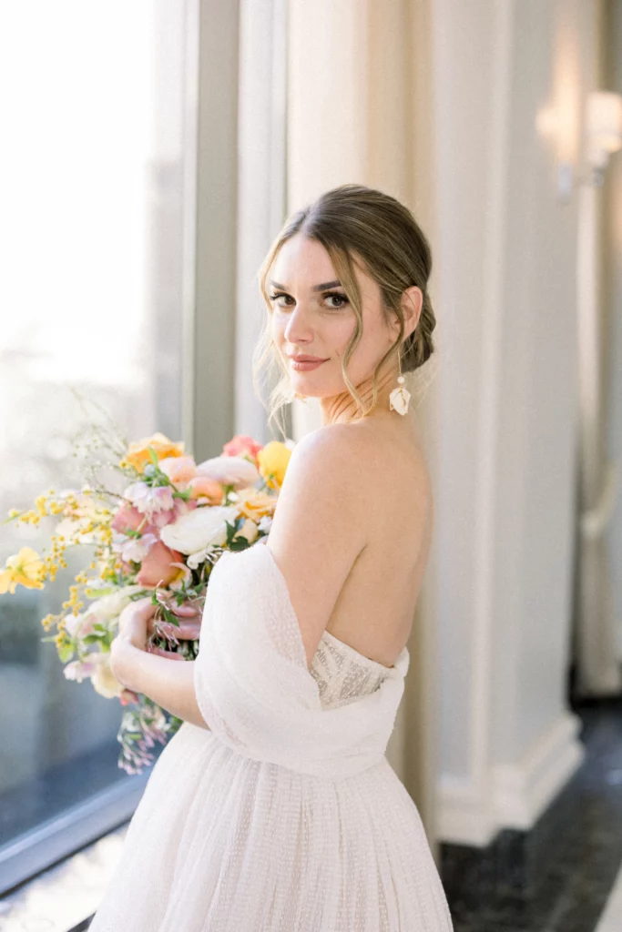 bride looking over her shoulder while holding her bouquet the Waldorf Astoria Atlanta Wedding venue