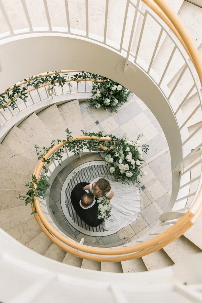 bride and groom standing at the bottom of a spiral staircase at a fernbank museum wedding