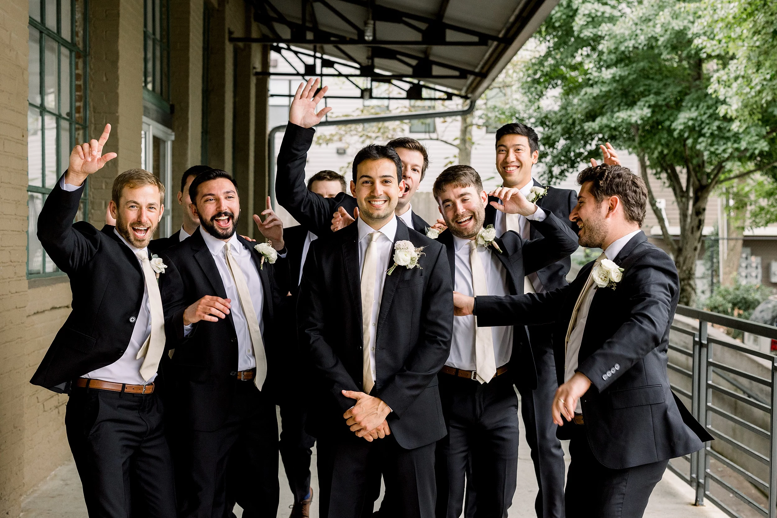 groomsmen cheering on the groom at his foundry at puritan mill wedding