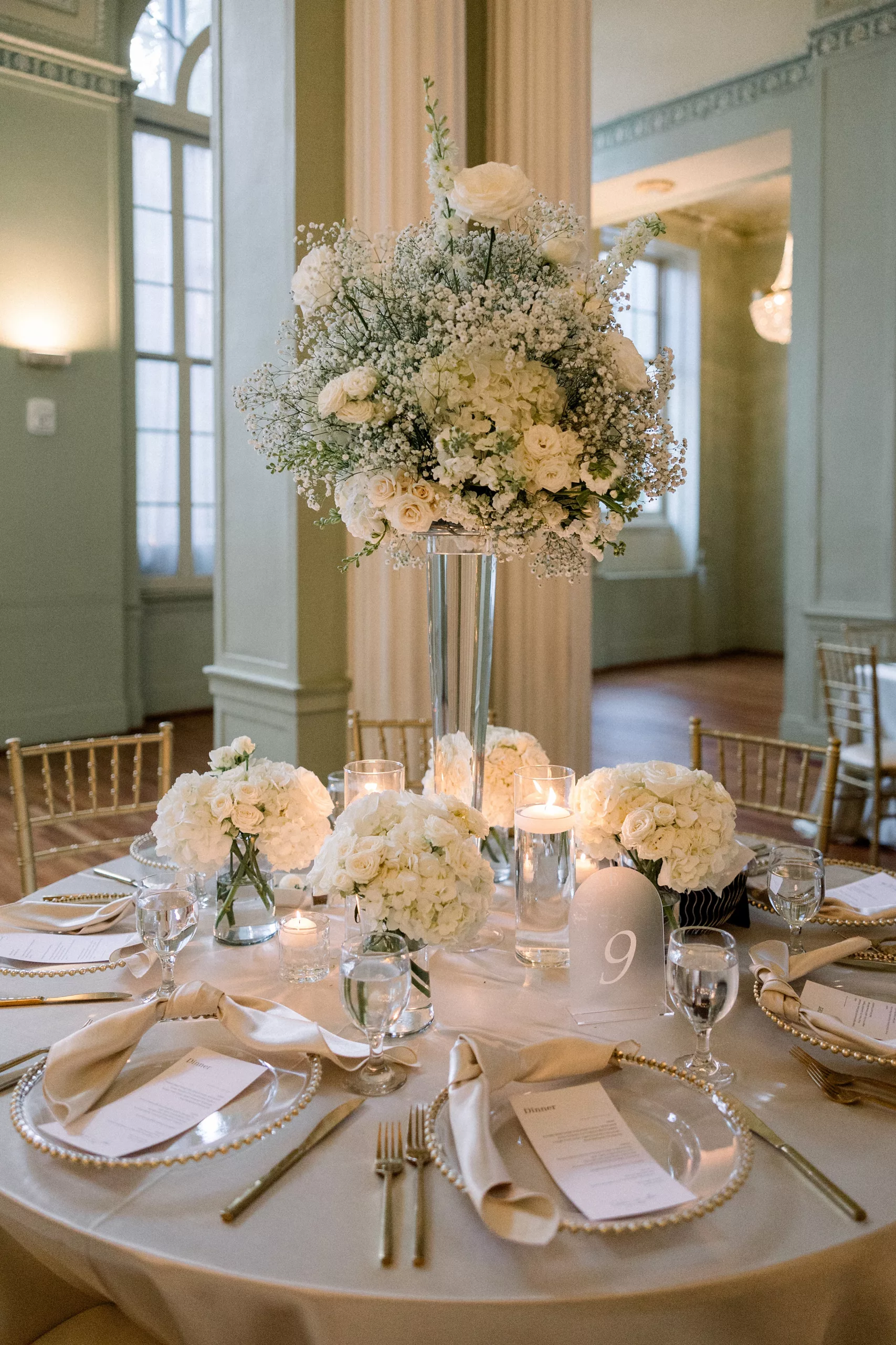 Details of a wedding reception table with large white flower centerpiece 