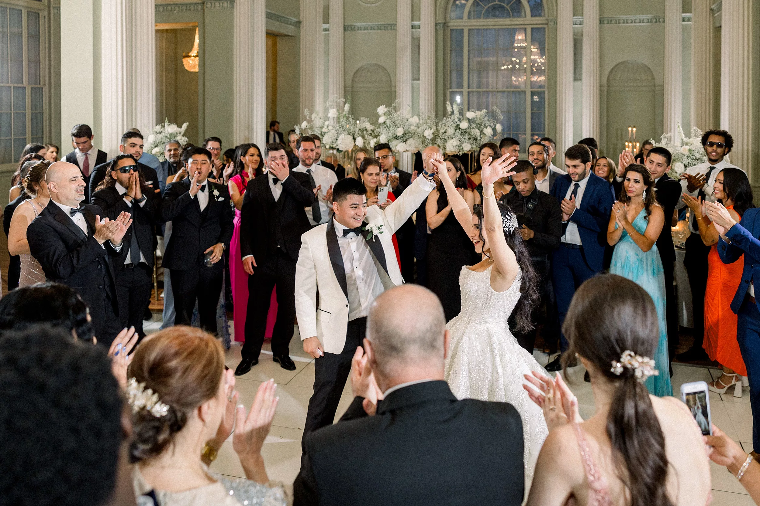 Newlyweds dance on while surrounded by guests at their wedding