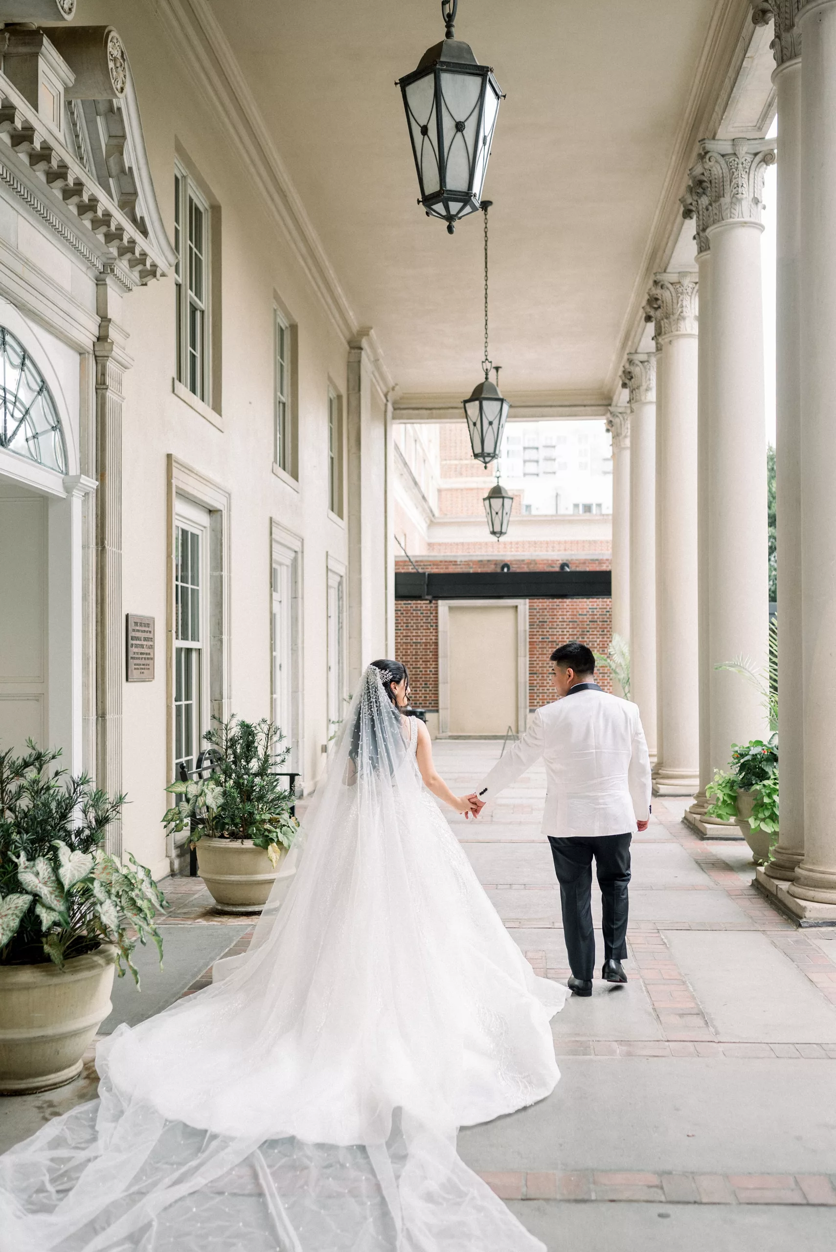 Newlyweds walk down the marble front porch of Biltmore Ballrooms Wedding venue