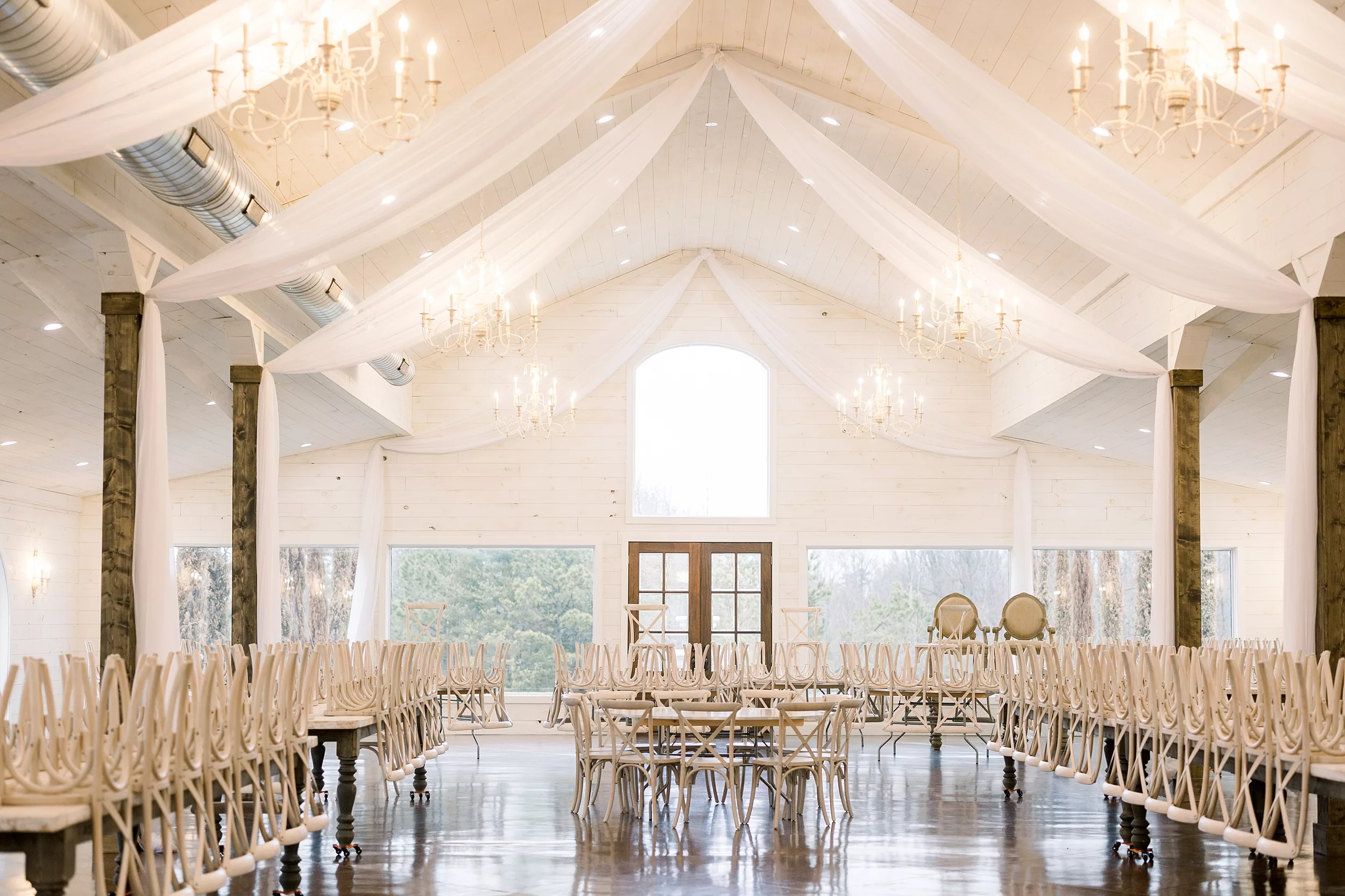 Details of a wedding reception venue with white chairs and marble tables 