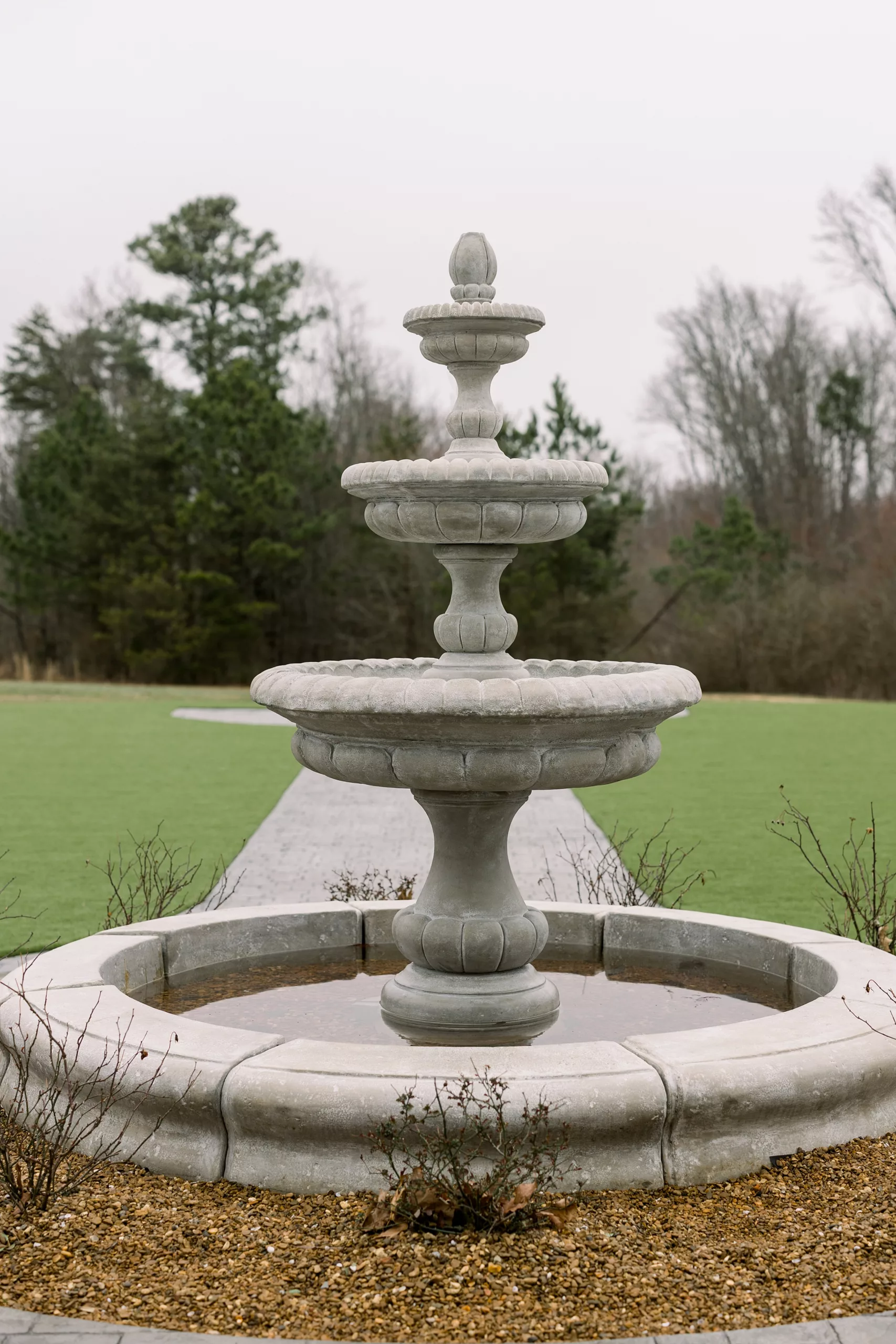A large stone fountain in the lawn of blackberry ridge wedding venue