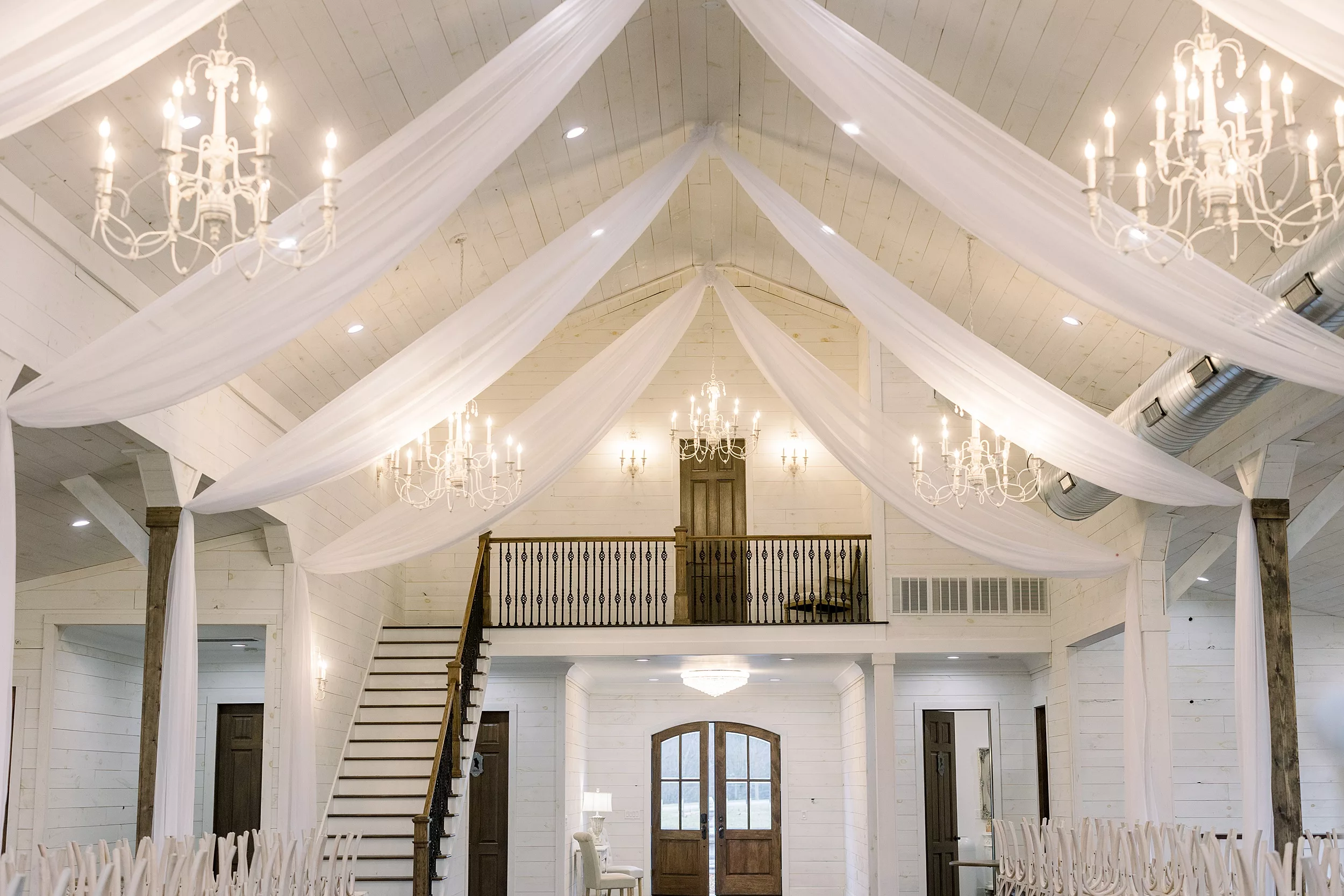 Chandeliers and white drapes hung in a wedding reception venue