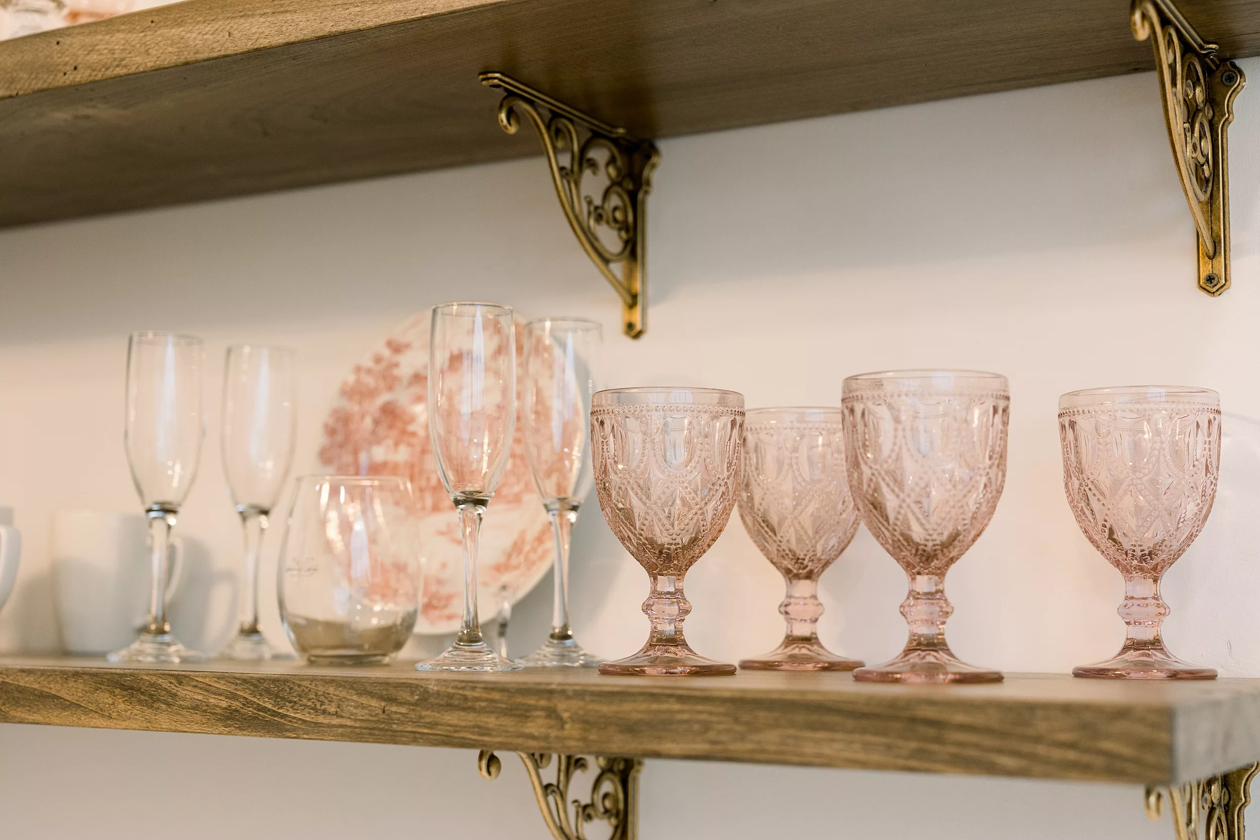 Details of flutes and glasses sitting on a wooden shelf