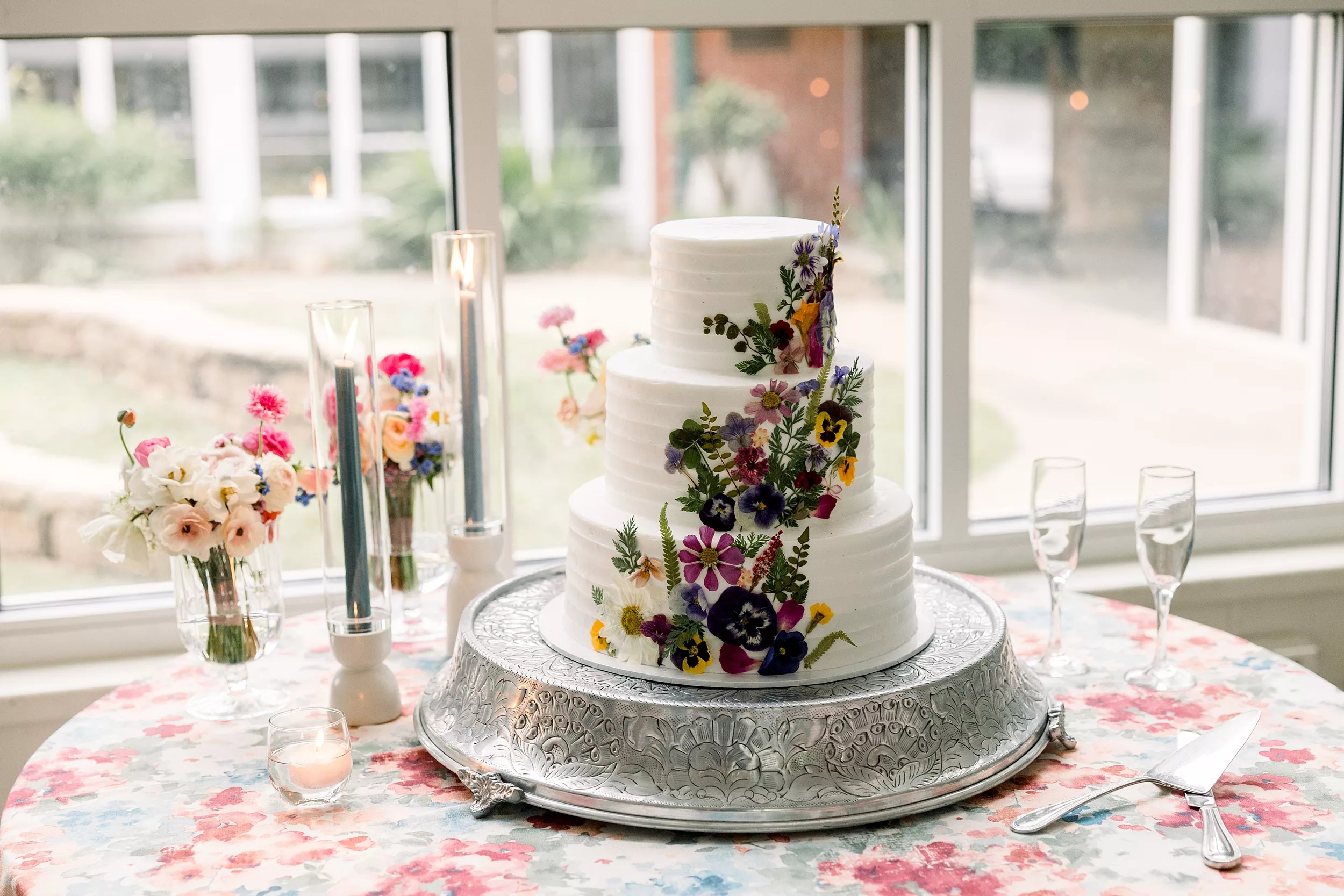 Details of a wedding cake on a silver platter with floral decorations