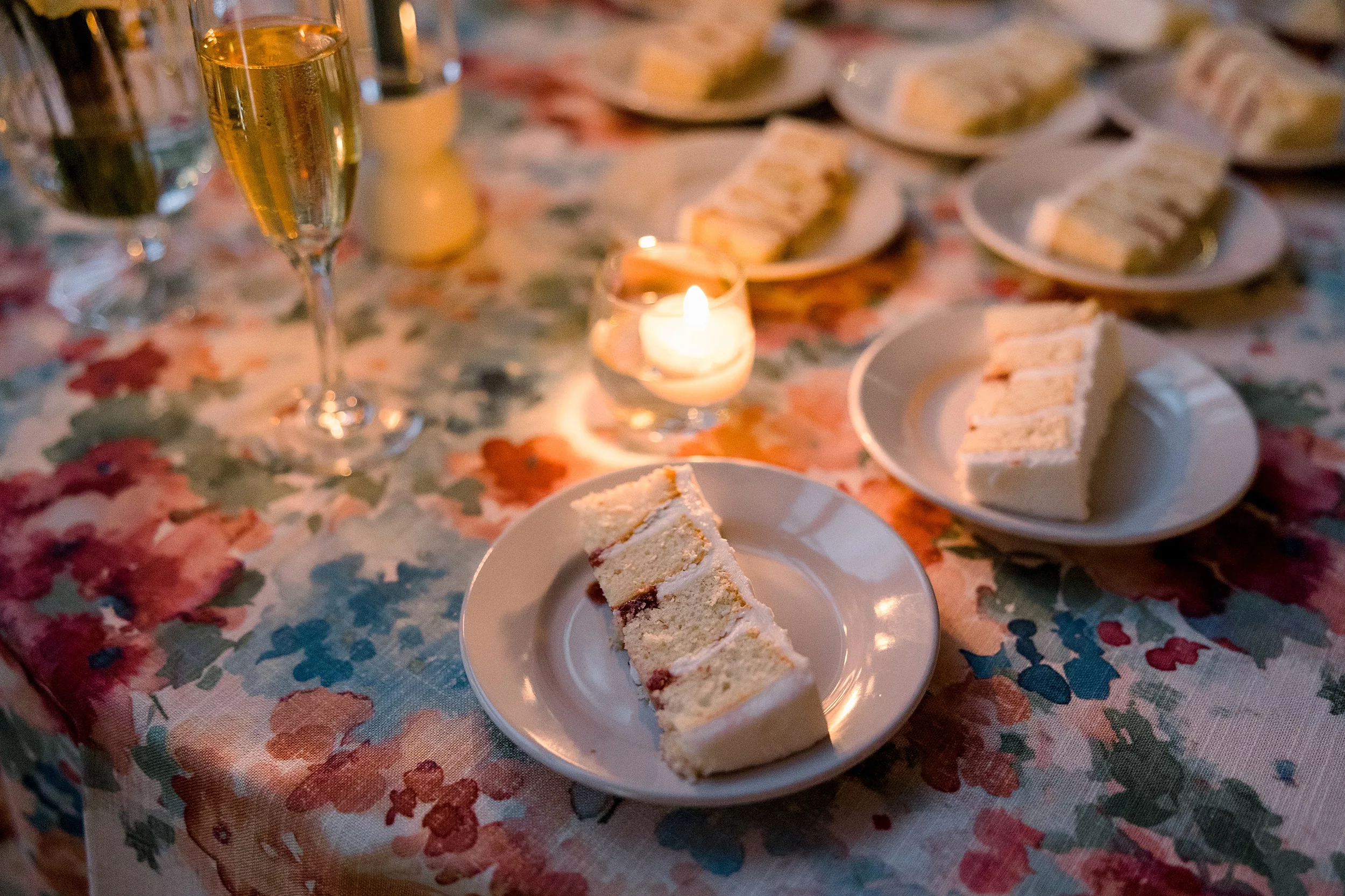 Details of cake and champagne sitting on a wedding reception table 