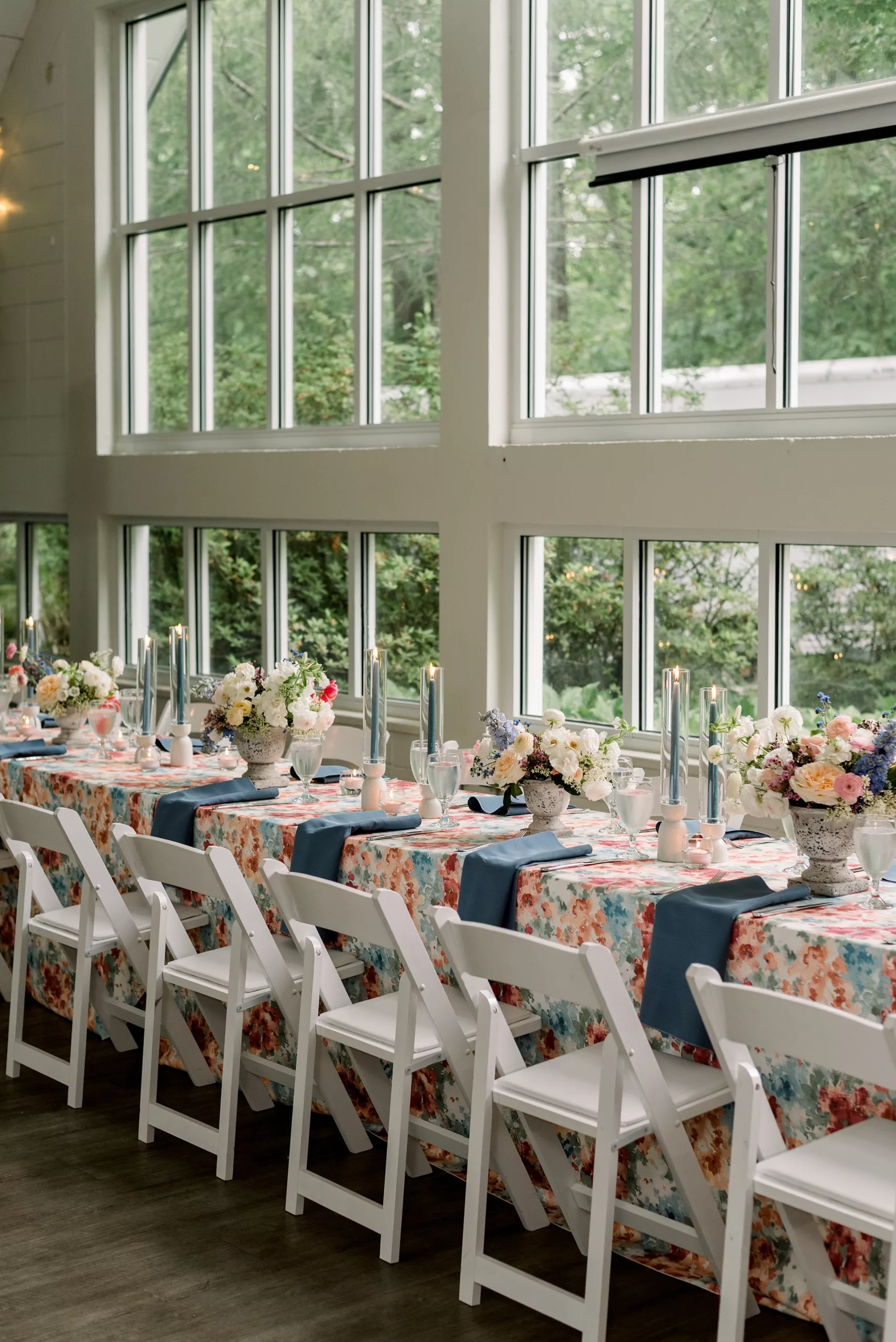 Details of a family style reception table set up in front of large windows 