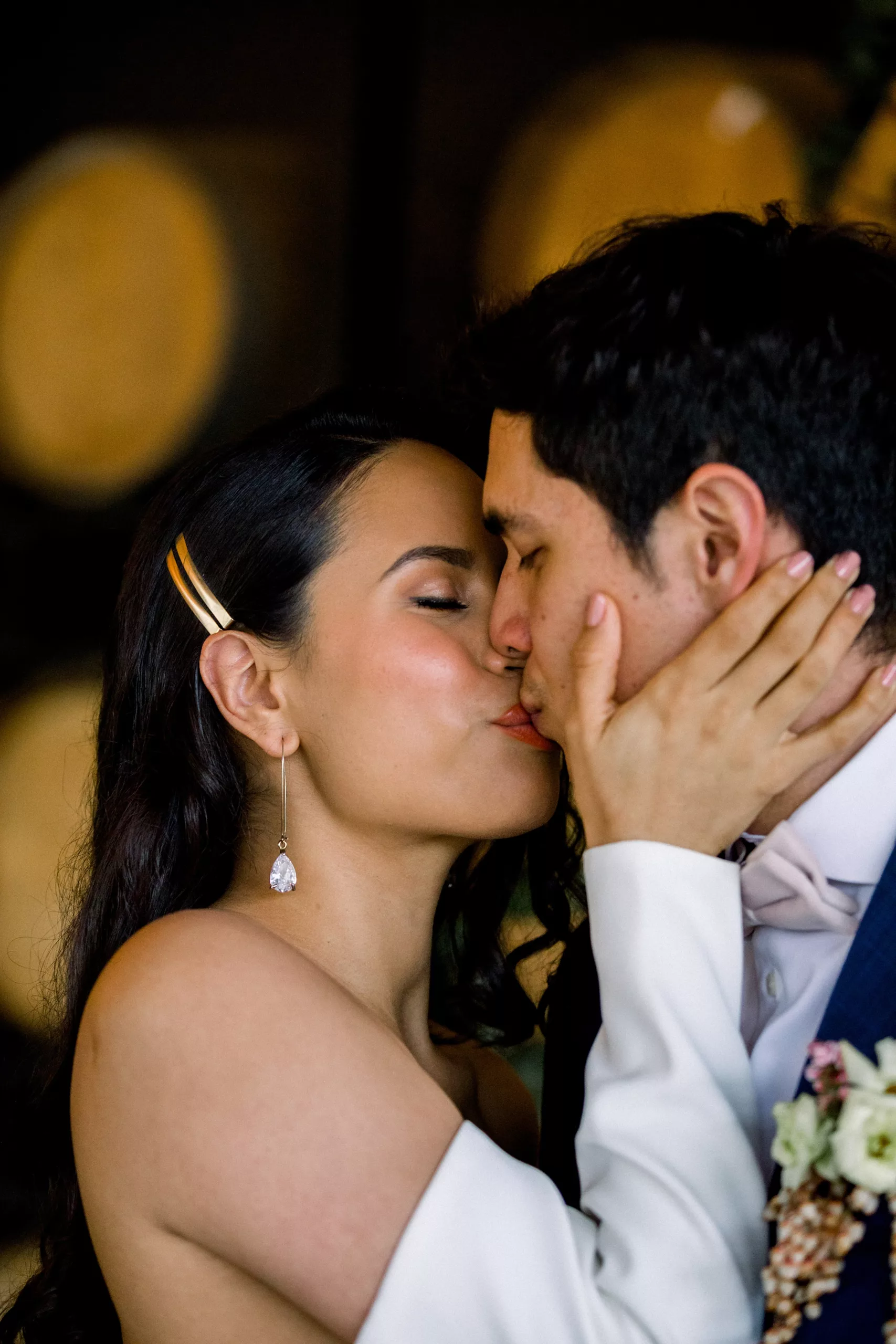 Newlyweds kiss in a room lined with wine barrels 