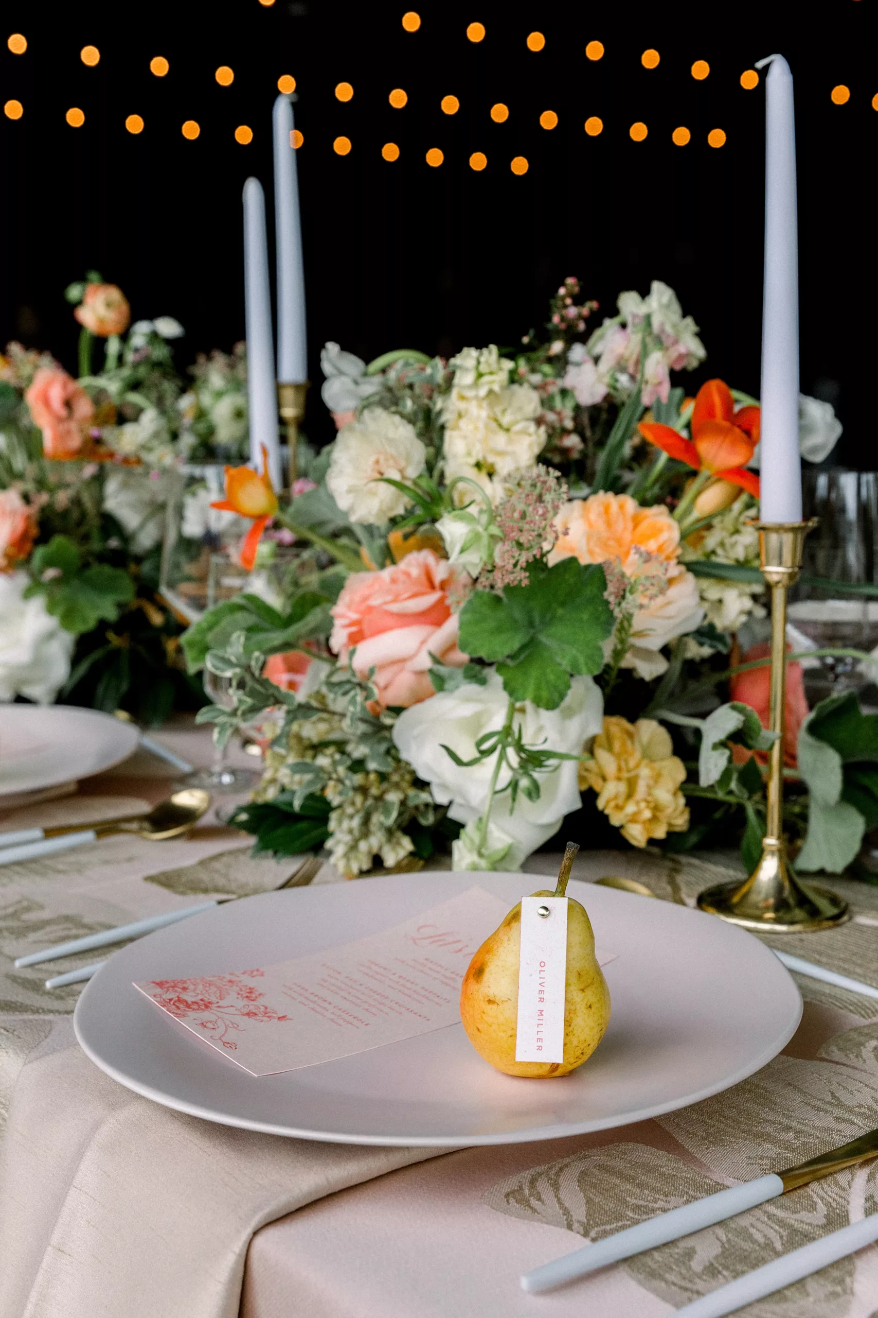 Details of an individual table setting at a Chateau Elan Wedding with a pear on each plate and colorful florals
