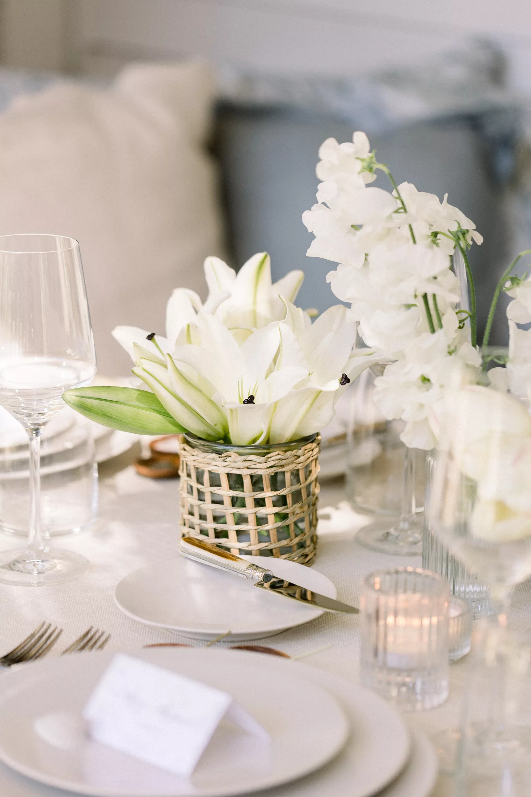 Details of a white themed table setting at a wedding reception