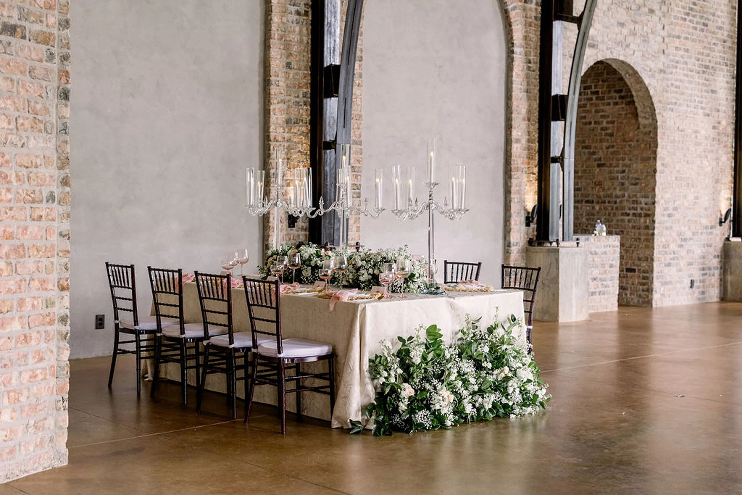 Details of a wedding reception table set up for eight with tall candles and white roses at the iron manor wedding