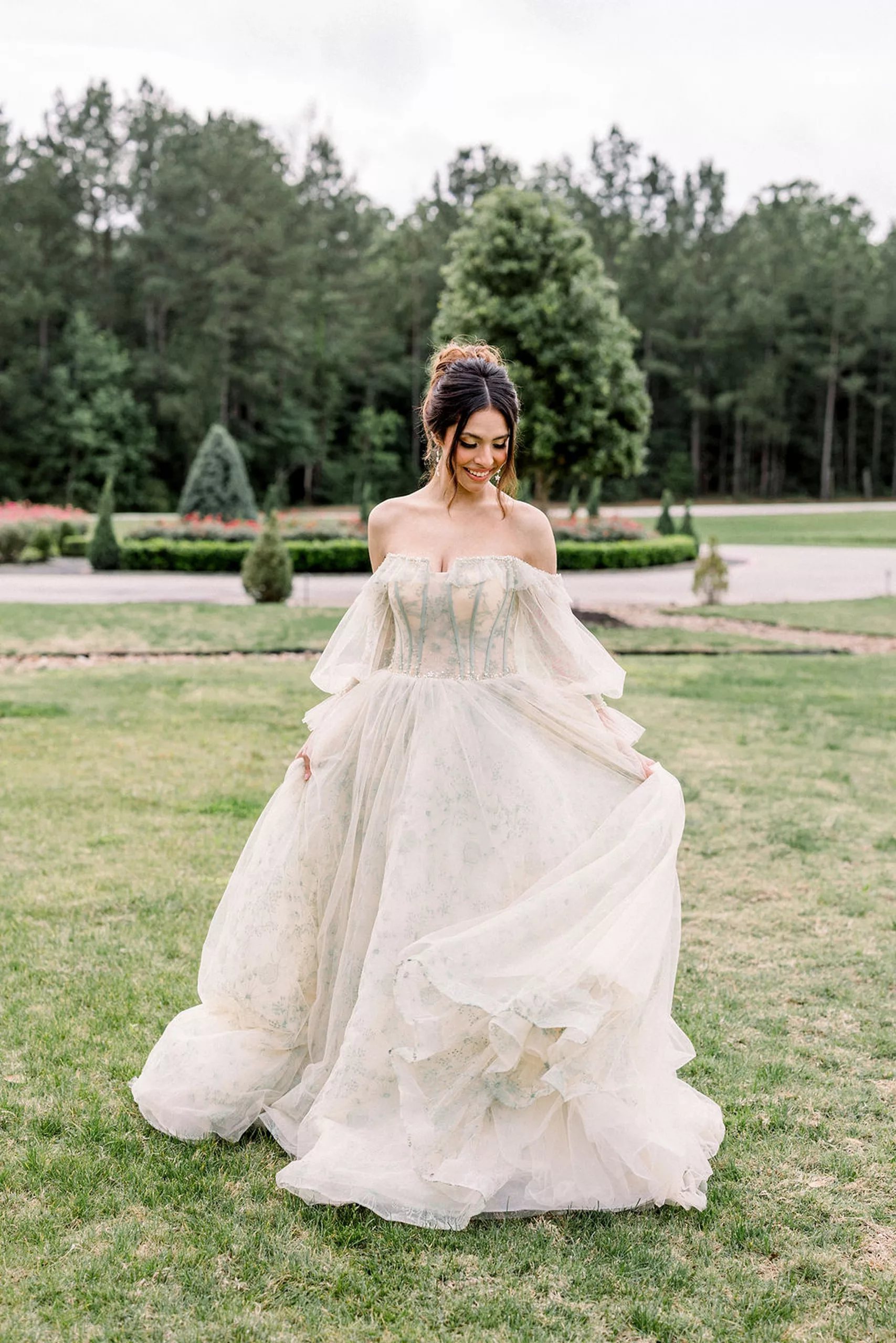 A bride in a beige dress twirls in a garden yard