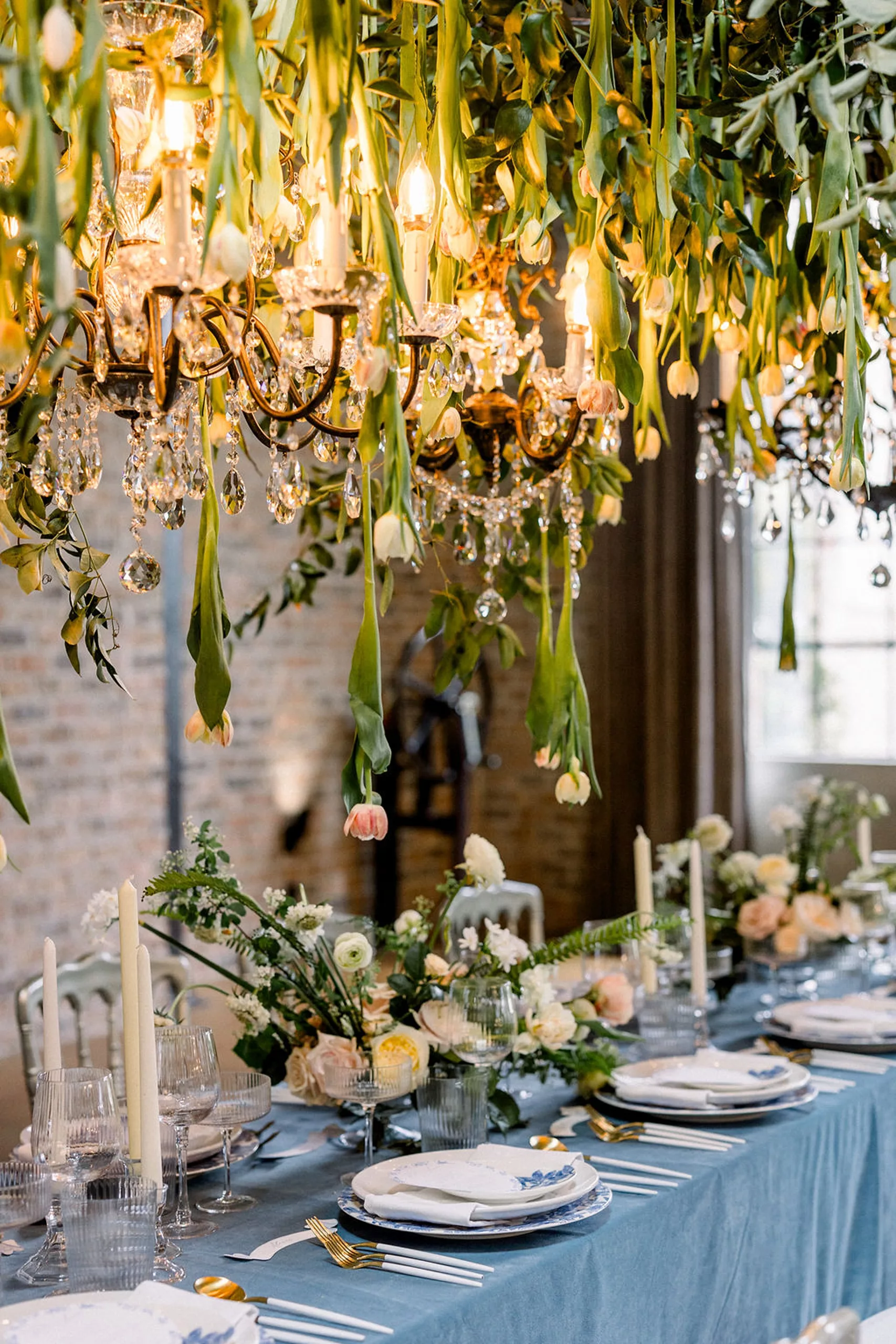 Details of a wedding reception table set up underneath floating tulips around chandeliers
