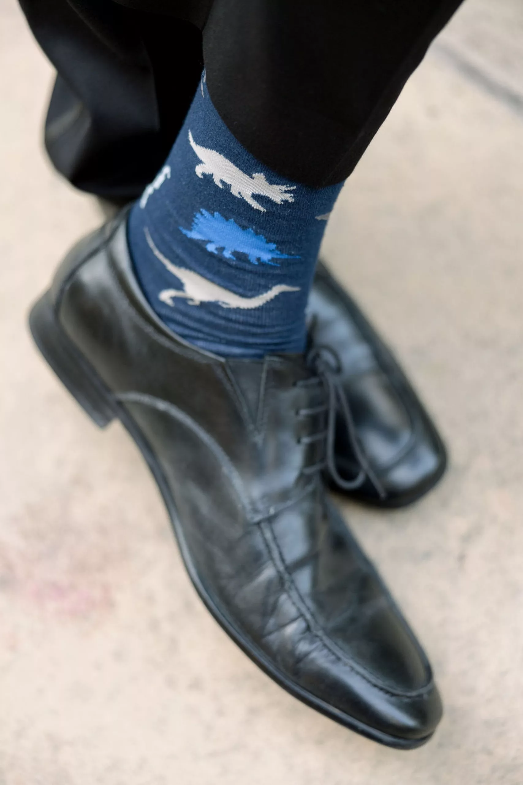 Details of a groom's dinosaur socks under his black pants for his jurassic park wedding