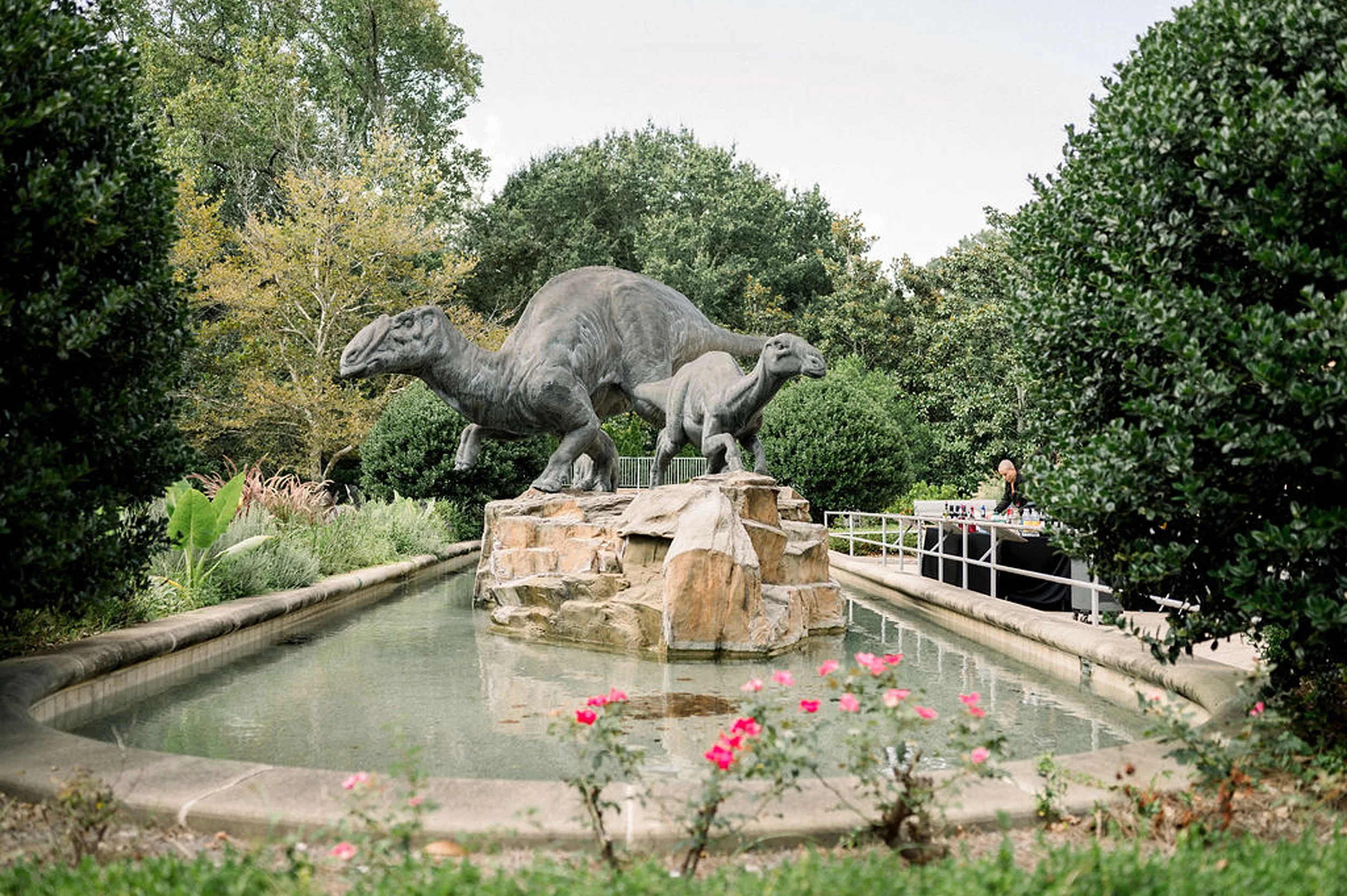 Details of dinosaur statues in a pond in a garden at a museum
