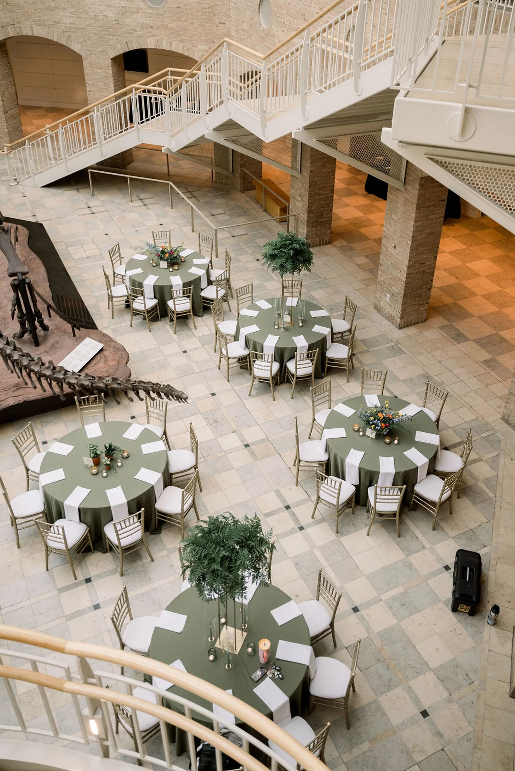 Details of wedding ceremony table set up with green linen under a dinosaur skeleton at a jurassic park wedding