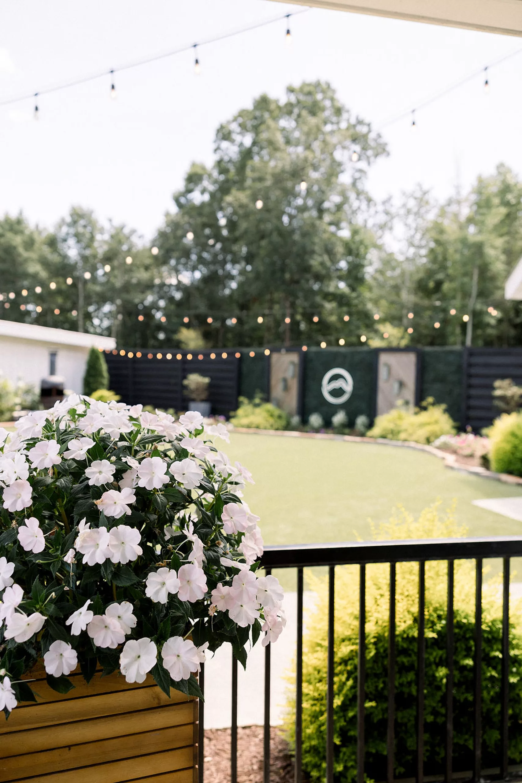 Details of a lawn set up for a wedding reception with market lights and white florals