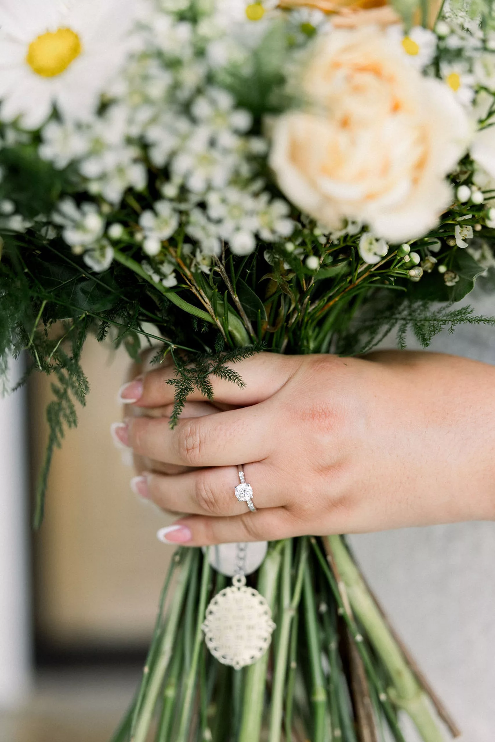 Details of a bride holding her bouquet before the ceremony with her engagement ring hand