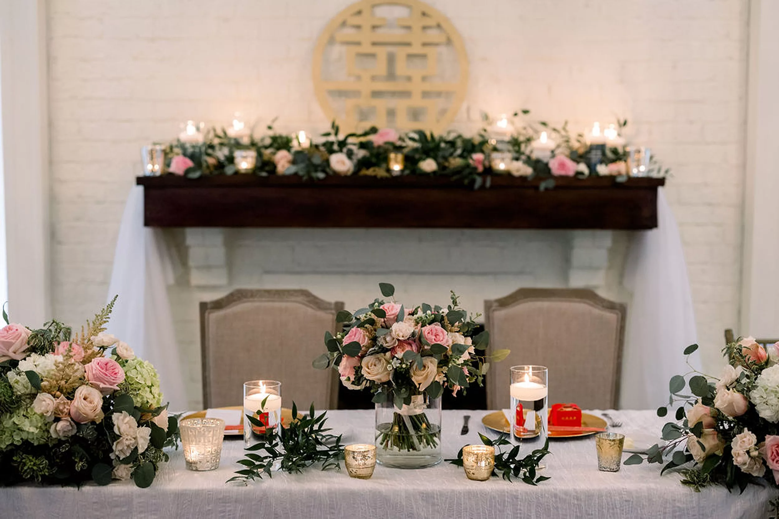 Details of a head table set up with pink flowers and candles at a payne-corley house wedding