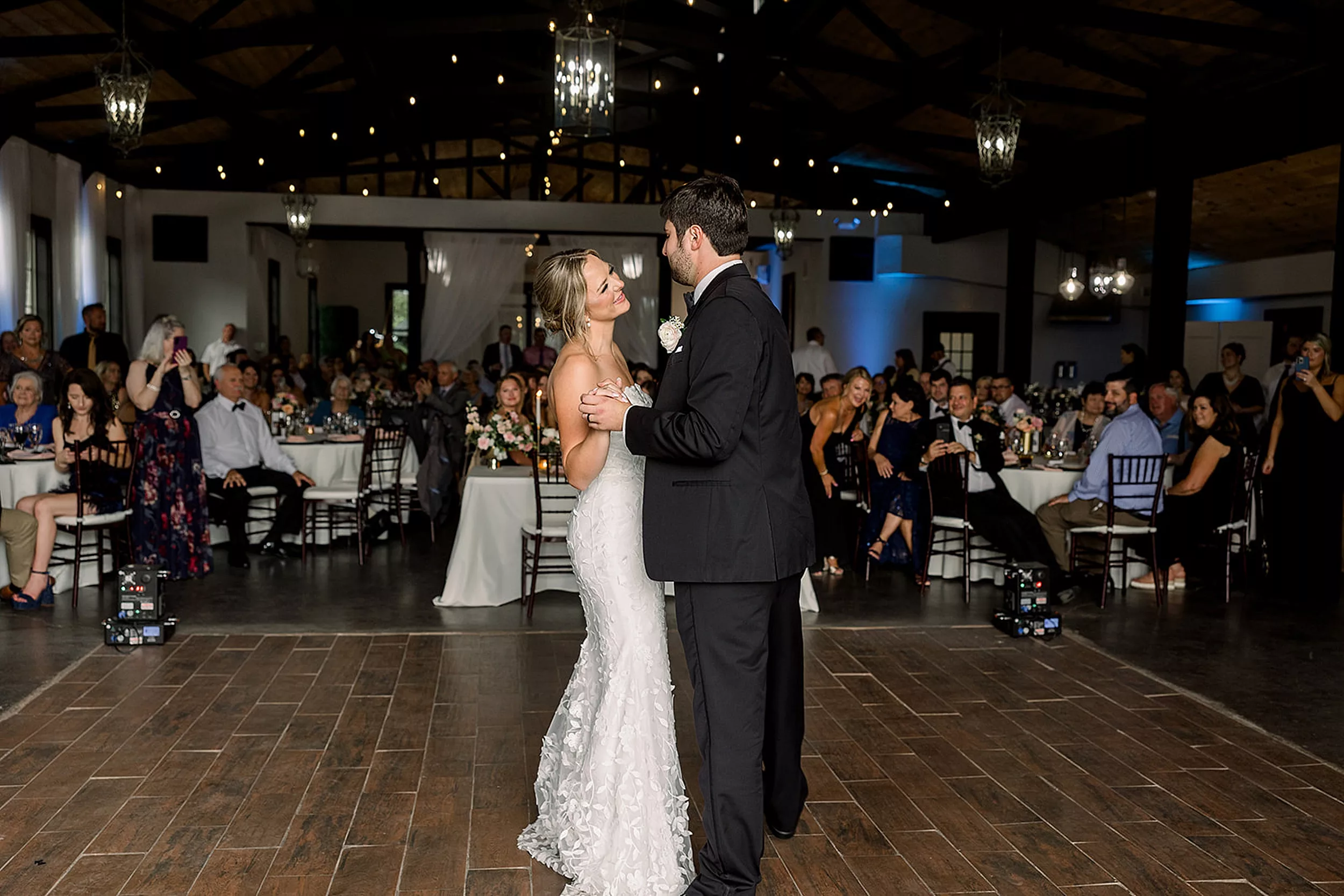 Newlyweds dance together alone for the first time at their White Oaks Vineyard reception while their guests look on from their seats