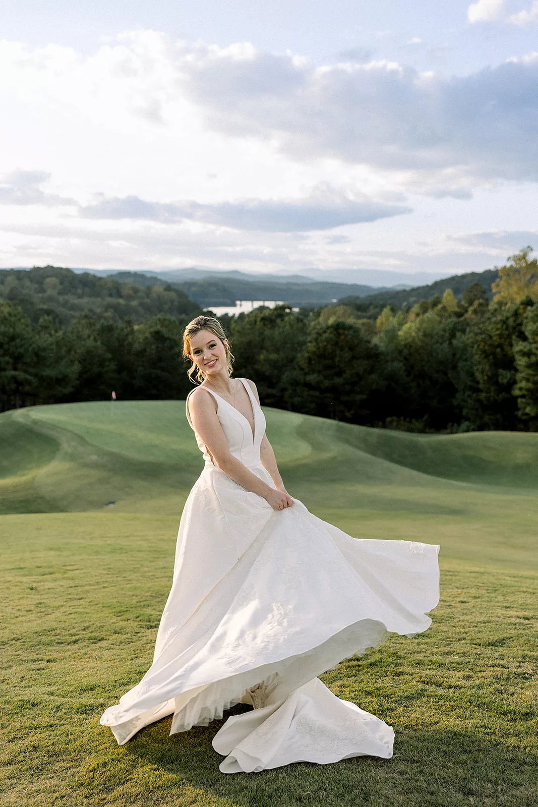 A bride twirls in her dress on a golf course with a view at the Curahee Club Wedding venue
