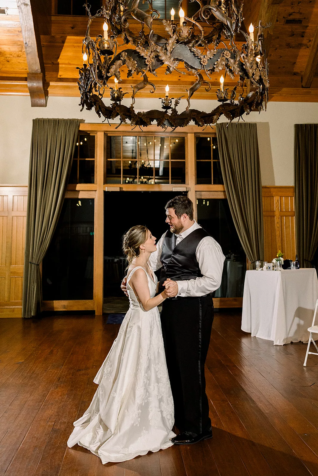 Newlyweds dance under an iron chandelier at the Curahee Club Wedding venue