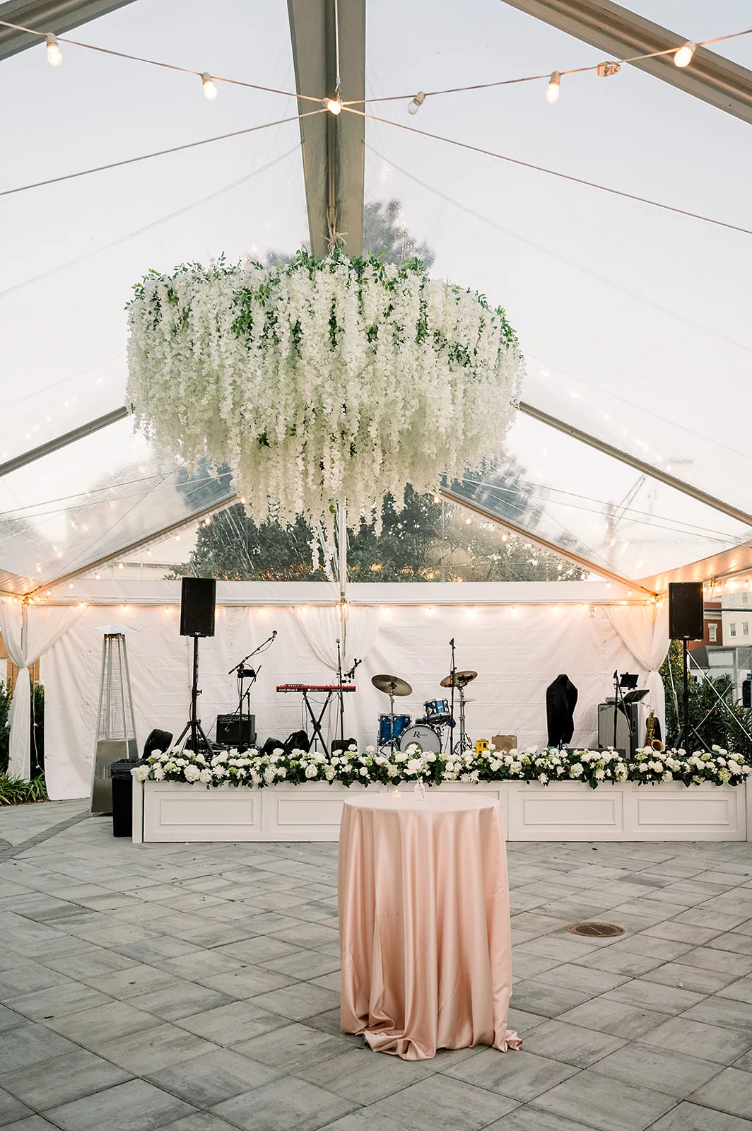 Details of a wedding reception band set up under a clear roof tent