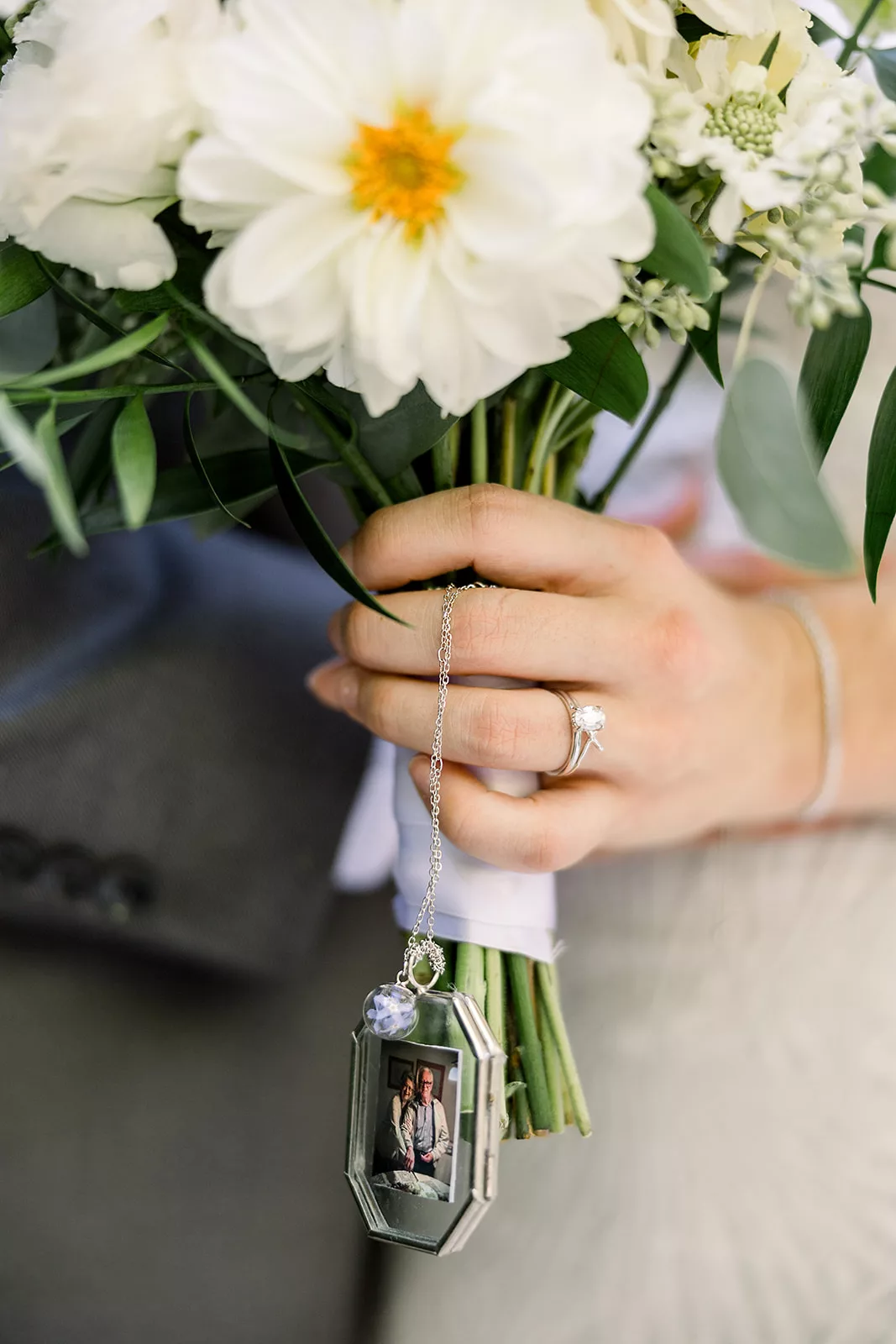 Details of a brides bouquet decorations and hand