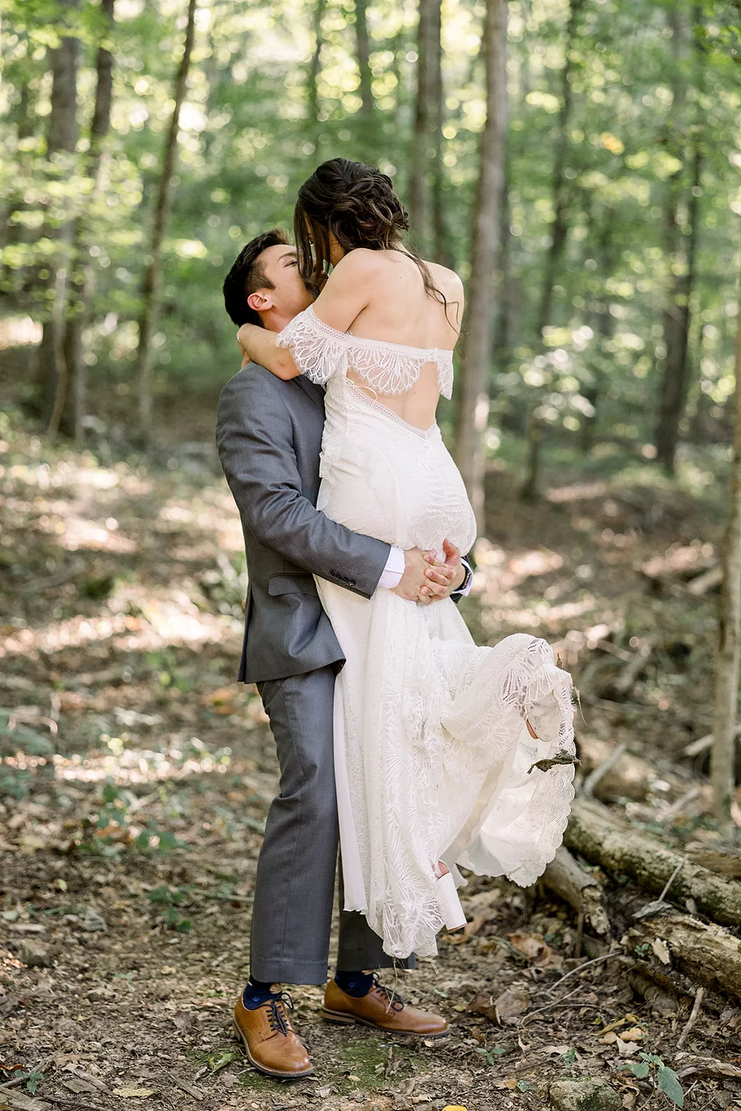 Newlyweds kiss while standing in the woods at a Sustainable Wedding Venue in Georgia
