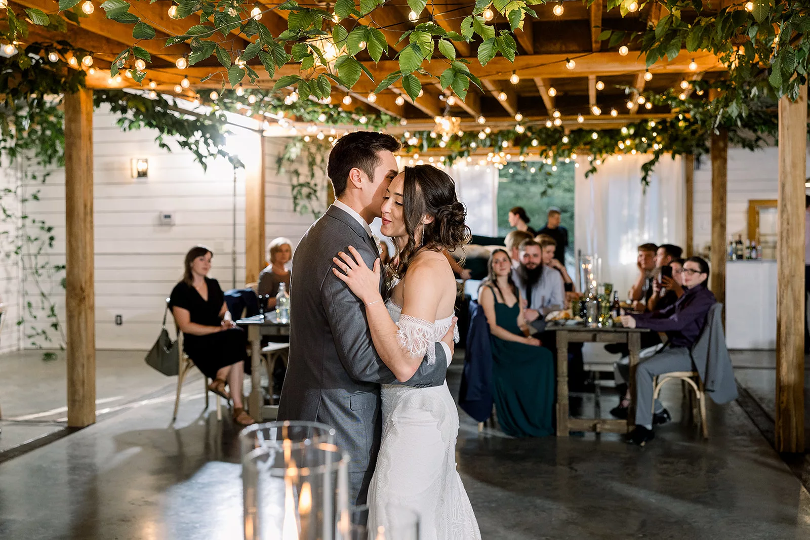 Newlyweds dance under a living rooftop in front of their guests at a Sustainable Wedding Venue