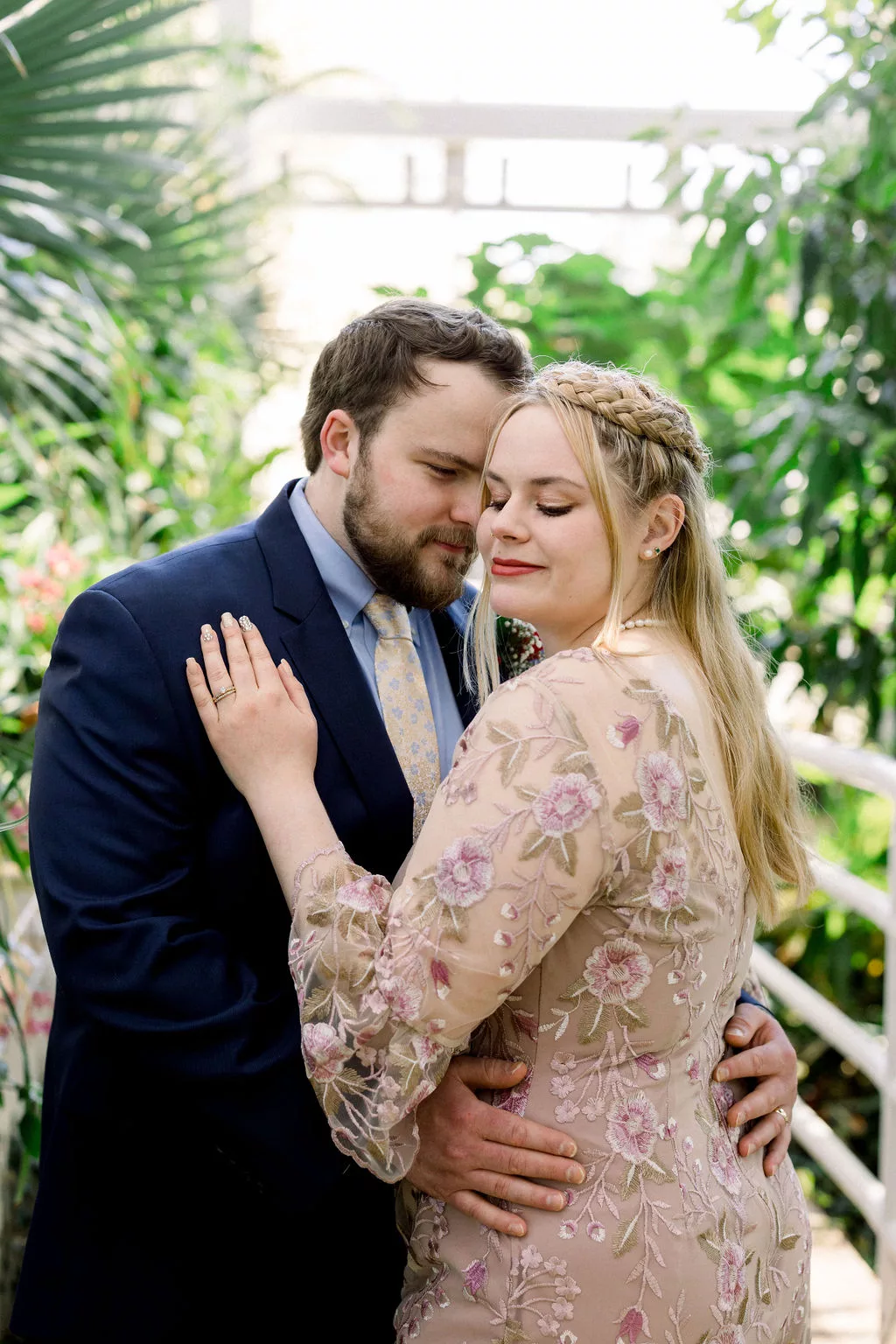 Newlyweds nuzzle while in a greenhouse walkway at a uga botanical gardens wedding