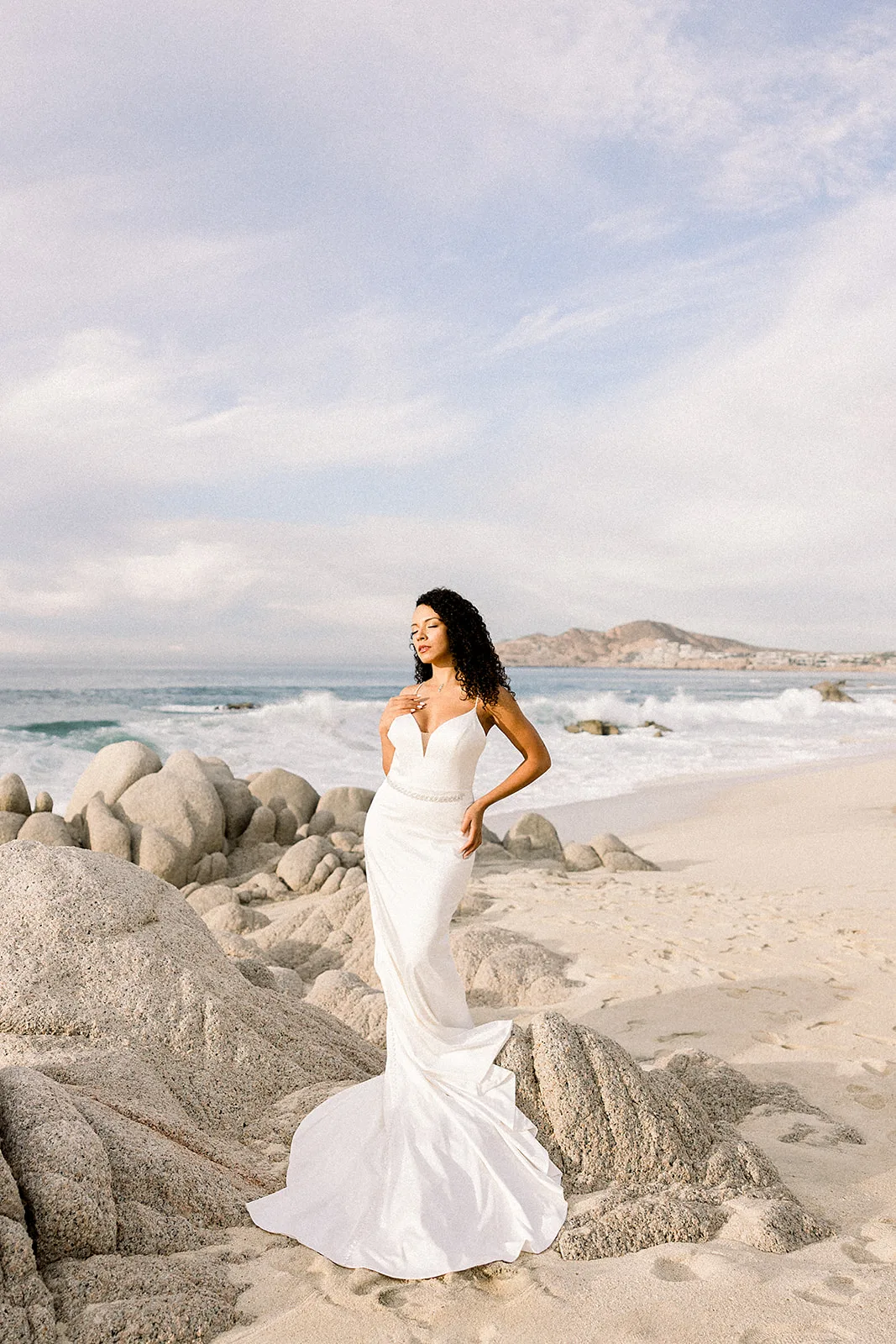 A bride walks along the beach in her silk gown and basking in the Mexican sun