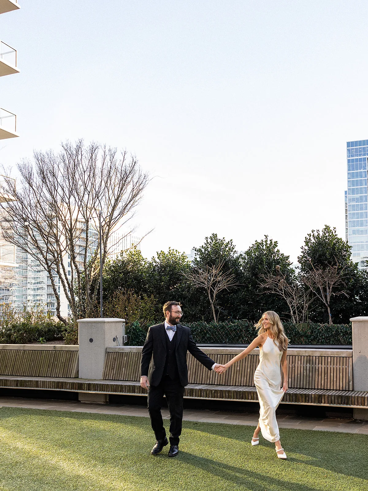 Newlyweds walk holding hands on the terrace at Epicurian Atlanta