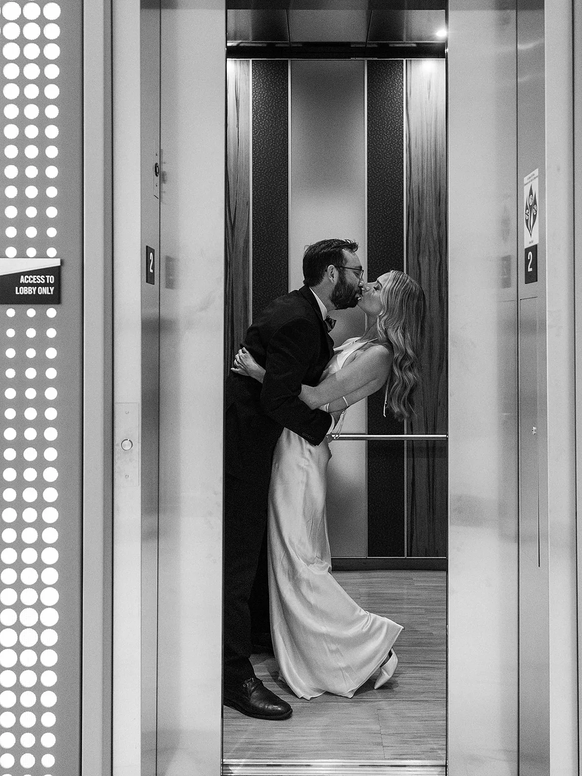 Newlyweds kiss in an elevator at their wedding at the Epicurian Atlanta