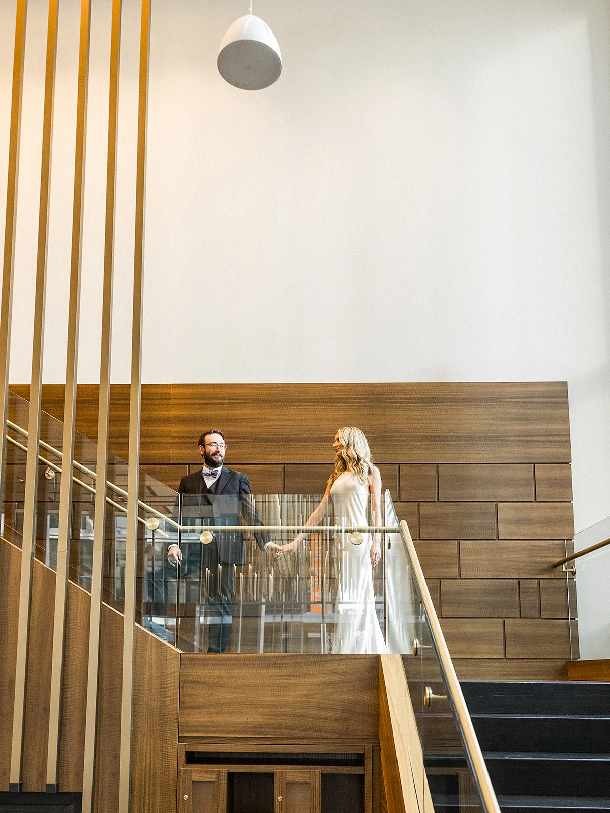 A groom leads his bride up a set up stairs by the hand during their wedding at the Epicurian Atlanta