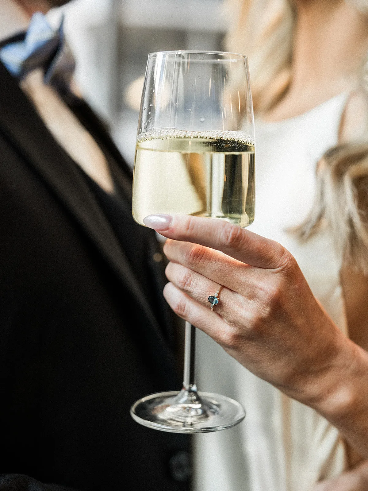 Details of a bride holding a glass of wine