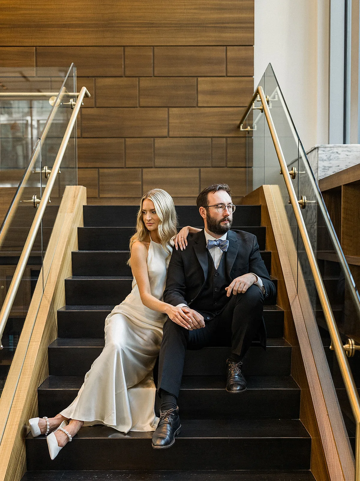Newlyweds sit together on modern stairs at their Epicurian Atlanta wedding