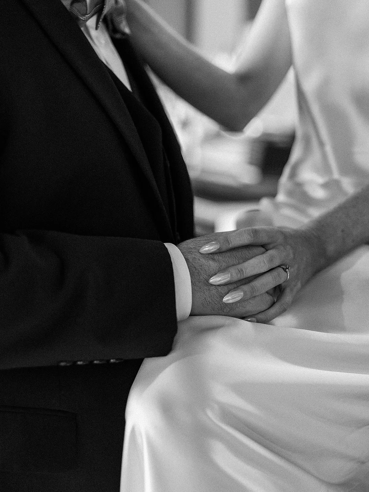 Details of newlyweds holding hands in black and white